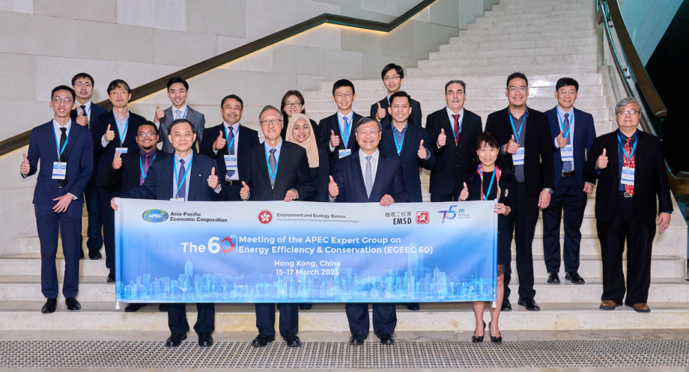 A group of people standing in two rows, posing and looking at the camera. The front row is holding a banner for the APEC EGEE&C Meeting.