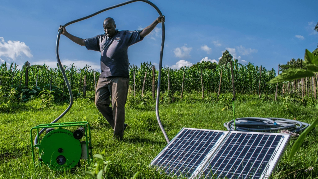 Man carrying hose for solar-powered water pump
