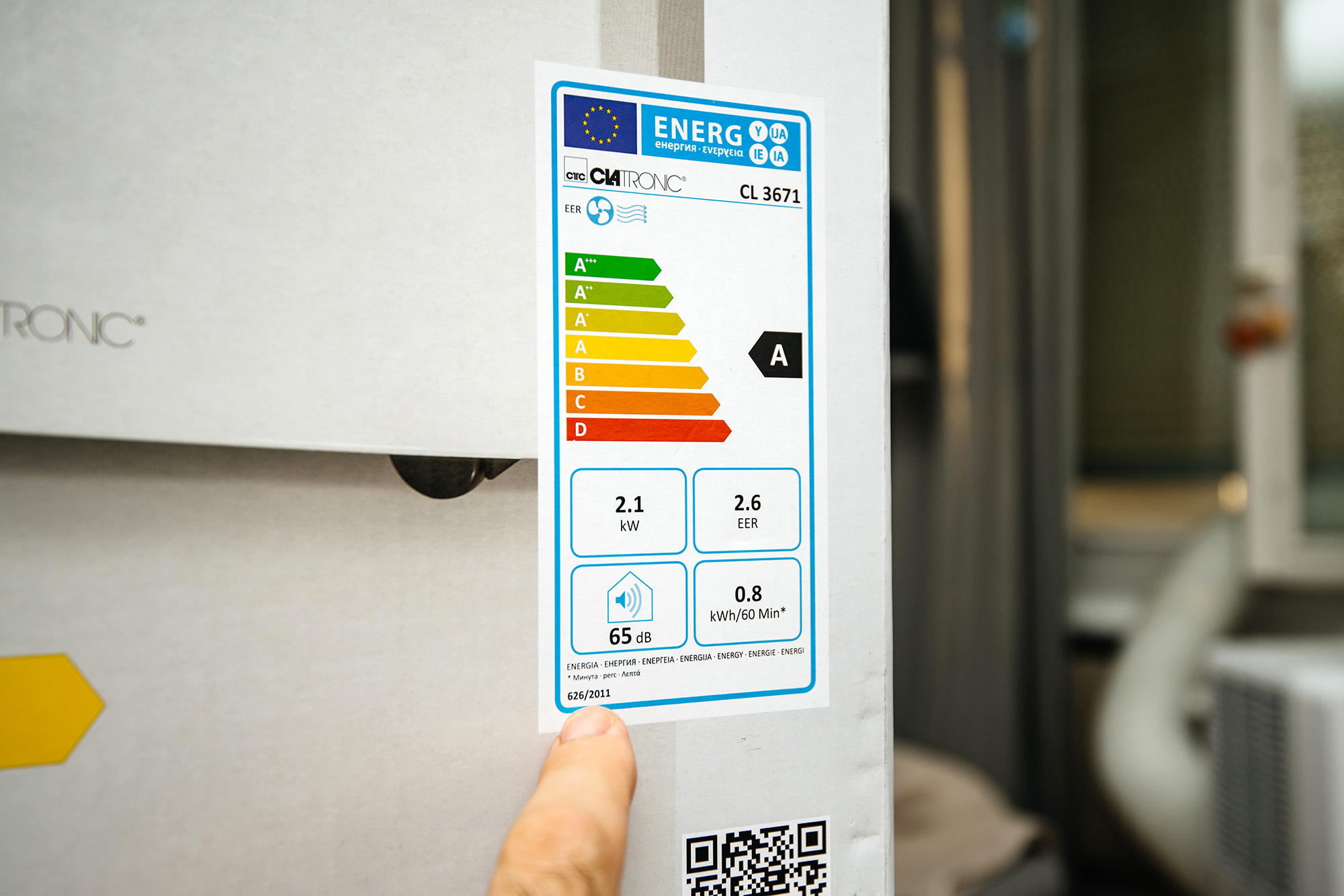 A person points to an energy label on an appliance